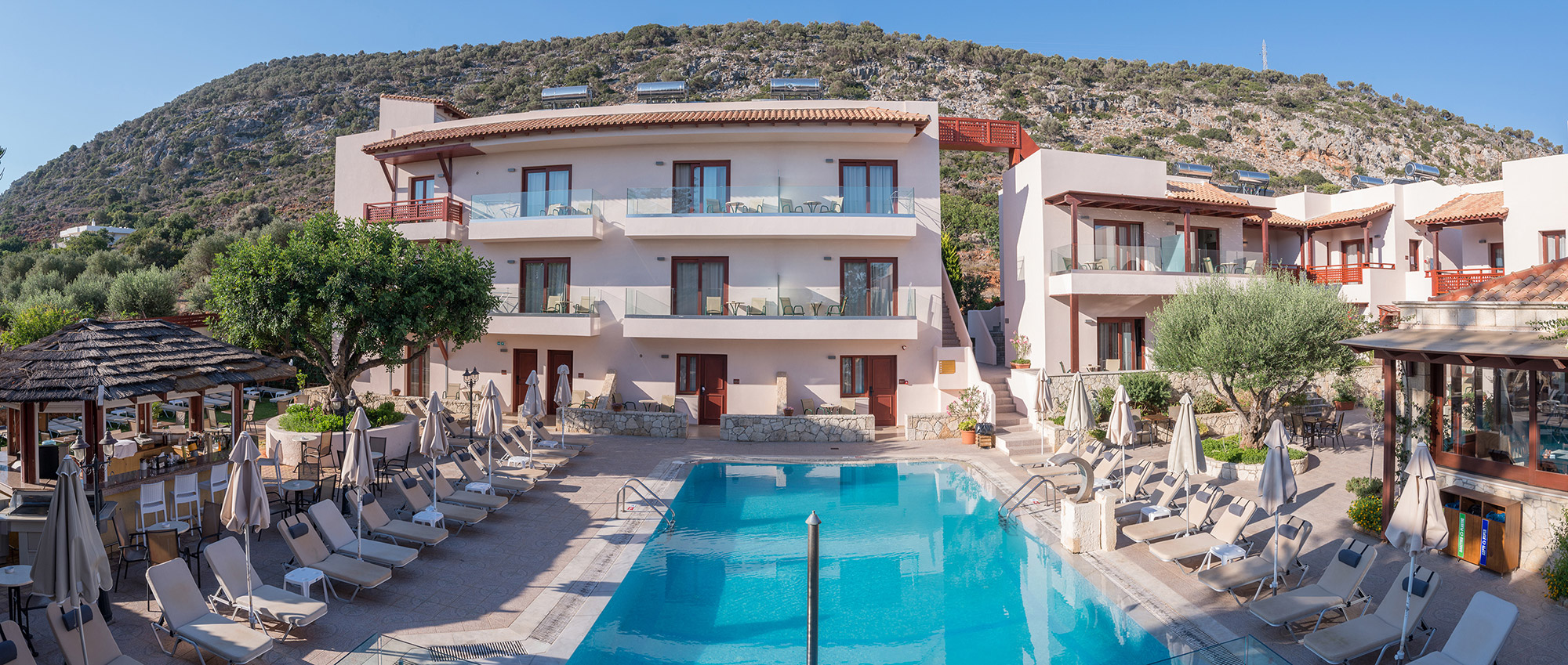 Rooms and pool of the Cactus village hotel that overlooks the mountain