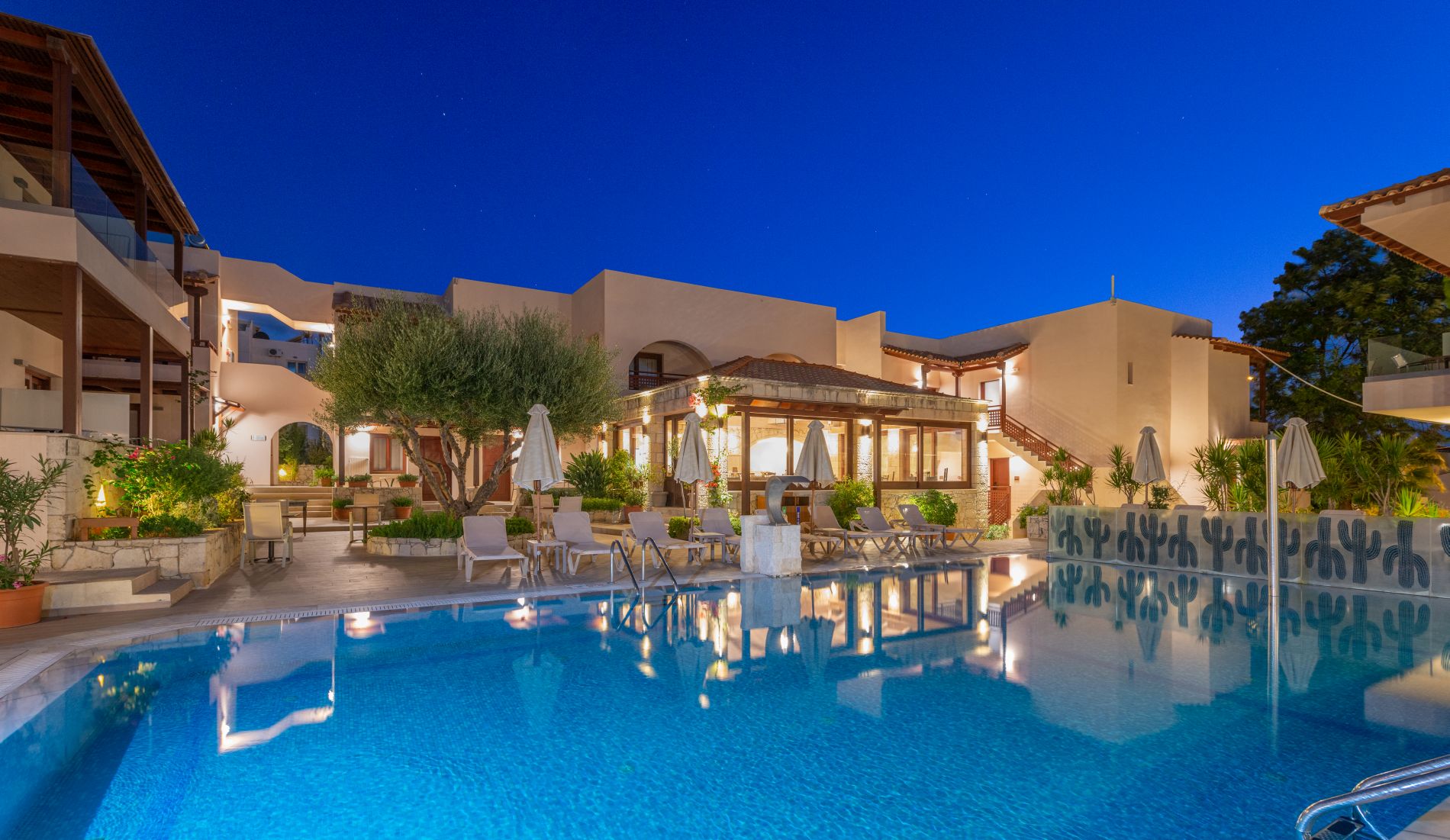 Swimming pool with sunbeds and sky view at the hotel Cactus village